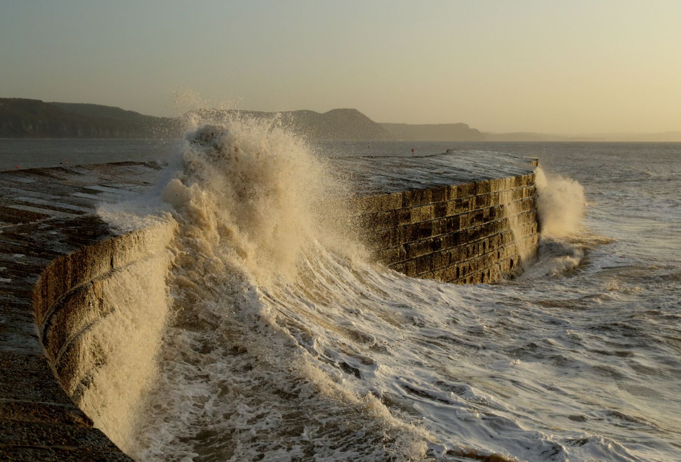 Waves crashing over the cobb in Lyme regis