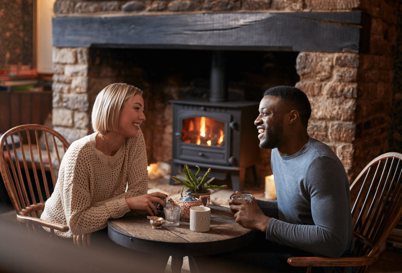couple sat by fire in cosy winter pub