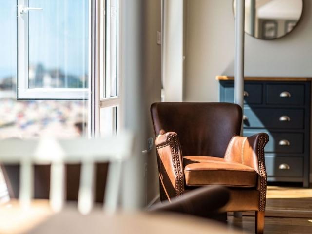 Arm Chair in living room with sun beaming in through window. 