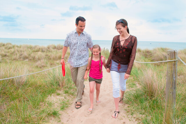 Family walking together on the beach 