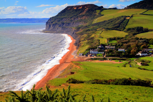 Seatown Beach with red sand and green hills
