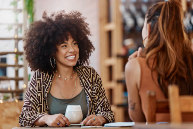 Woman drinking coffee with friend