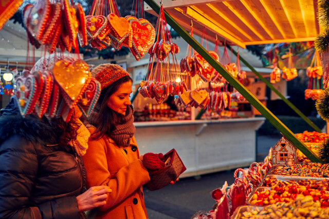 friends buying treats at Christmas market 