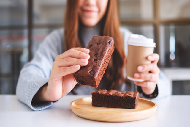 Close-up of woman eating brownie