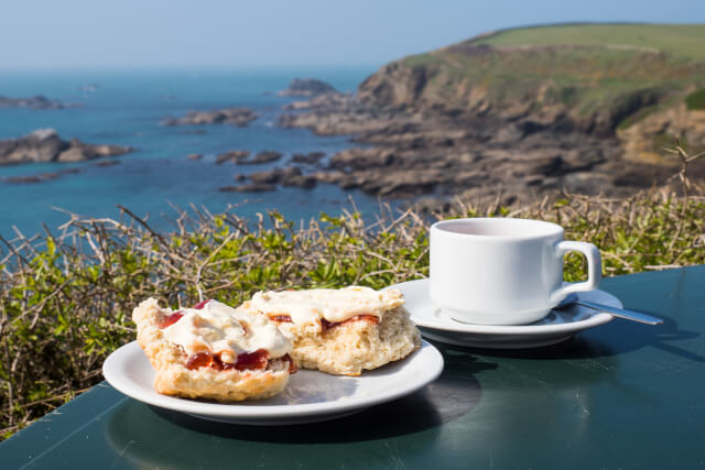 Cream tea with background of English coast
