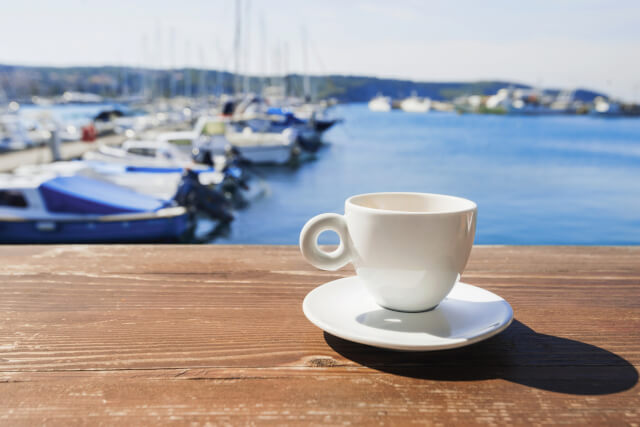 Cup of coffee with harbour in background