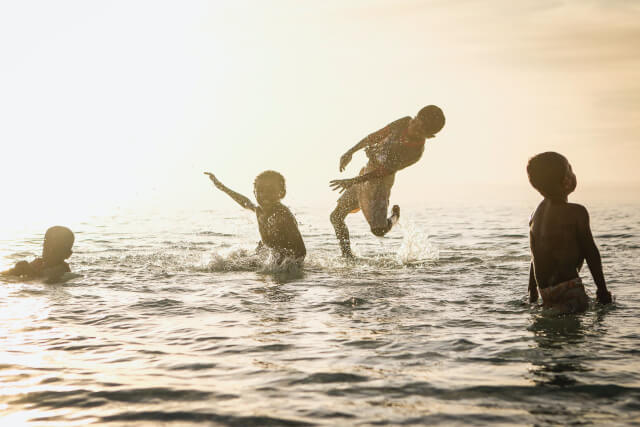 Family in water at sunset