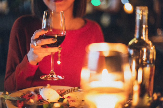 Woman holding glass of red wine at fine dining restaurant dorset